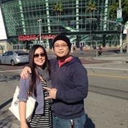 Two people standing outside a building; one wearing glasses.