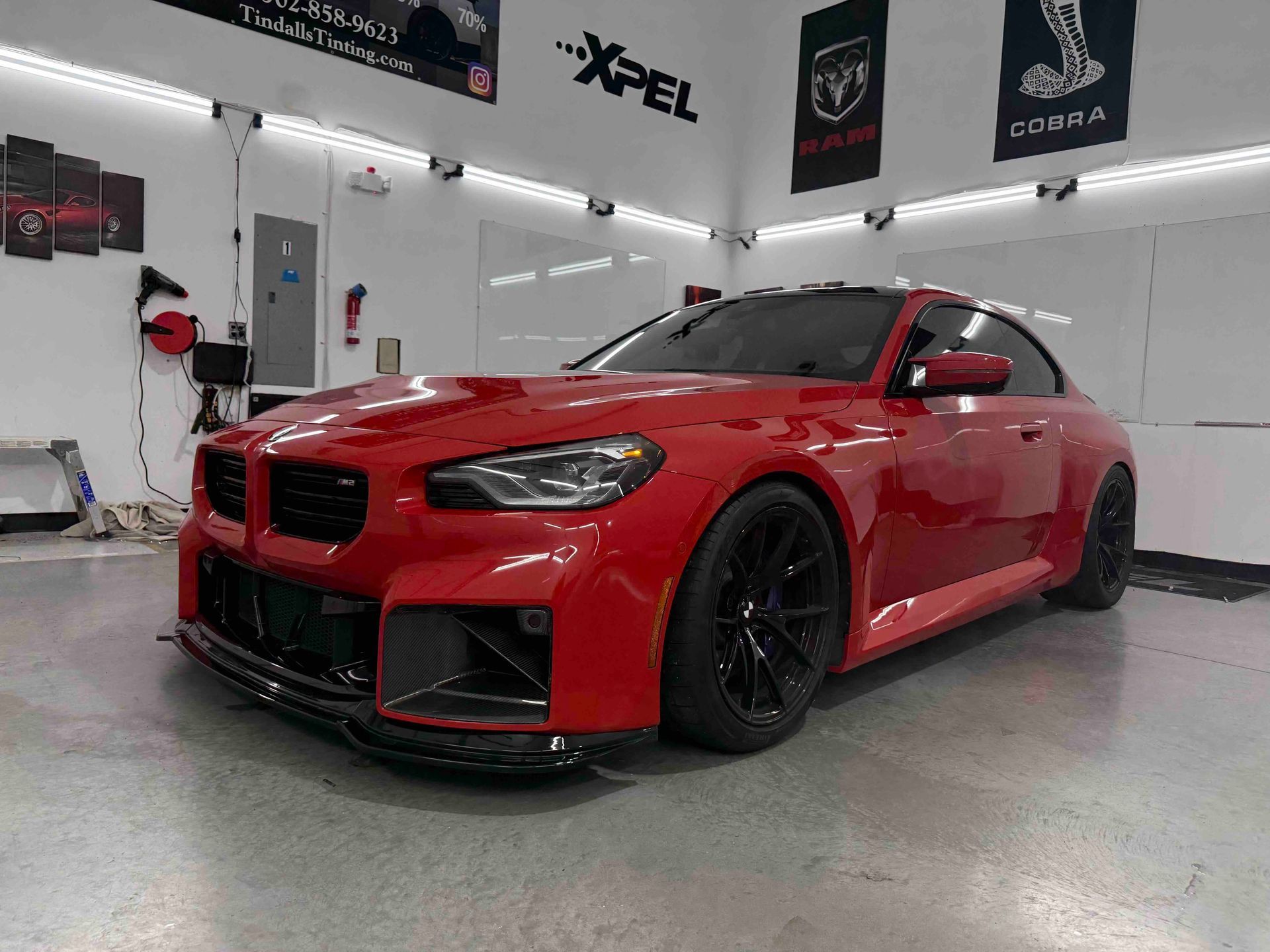 A red bmw m3 is parked in a garage.