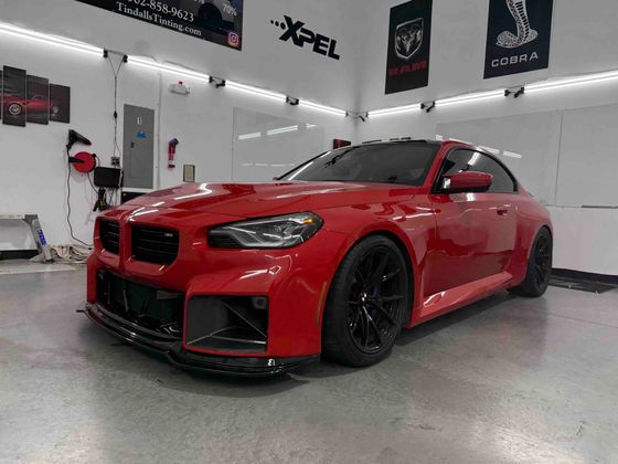 A red bmw m3 is parked in a garage.