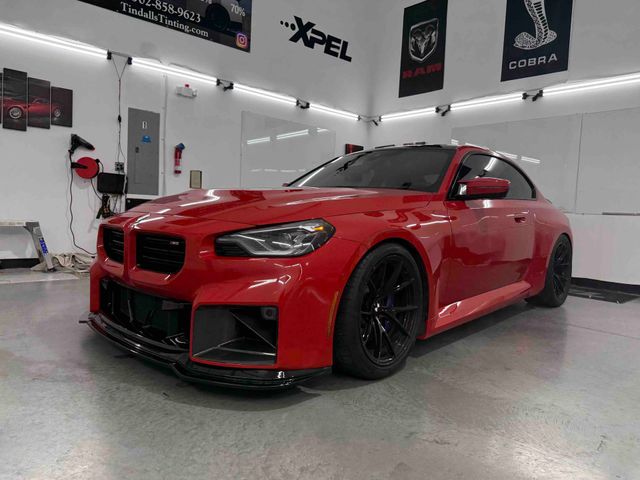 A red bmw m3 is parked in a garage.
