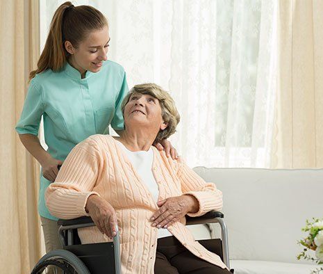 Infermiera con anziana su sedia a rotelle