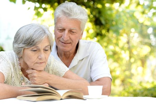 Coppia di anziani legge un libro