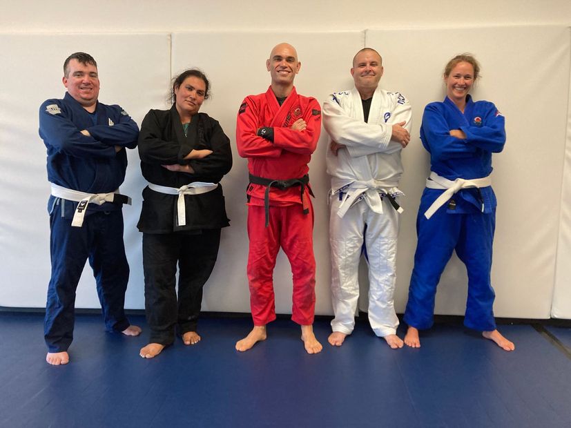 Beginner Jiu Jitsu Students Posing with Coach Mark.