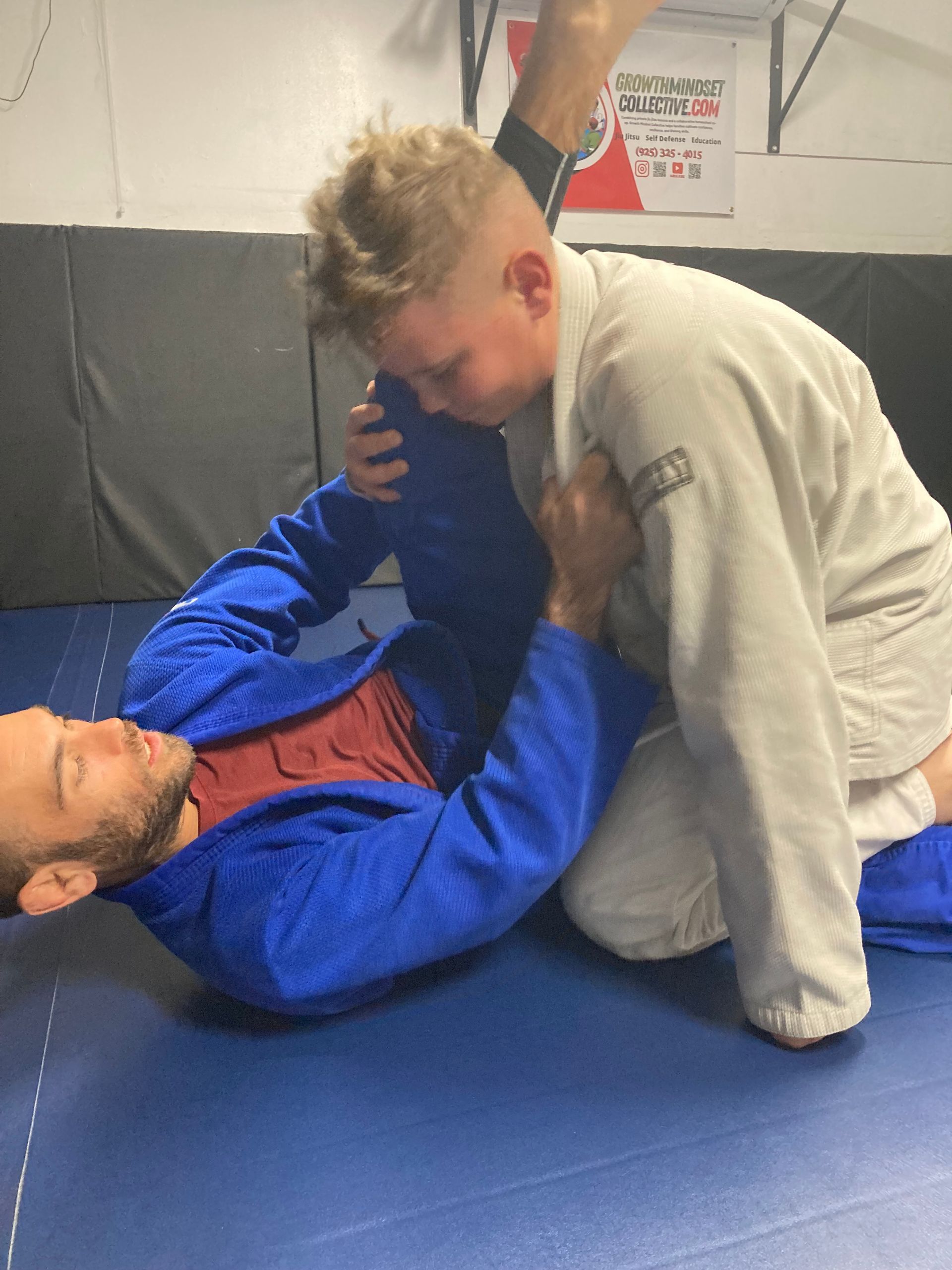 Coach Mark drilling jiu jitsu techniques with a student.