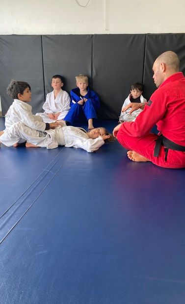 Coach Mark answering questions in a youth jiu jitsu class.