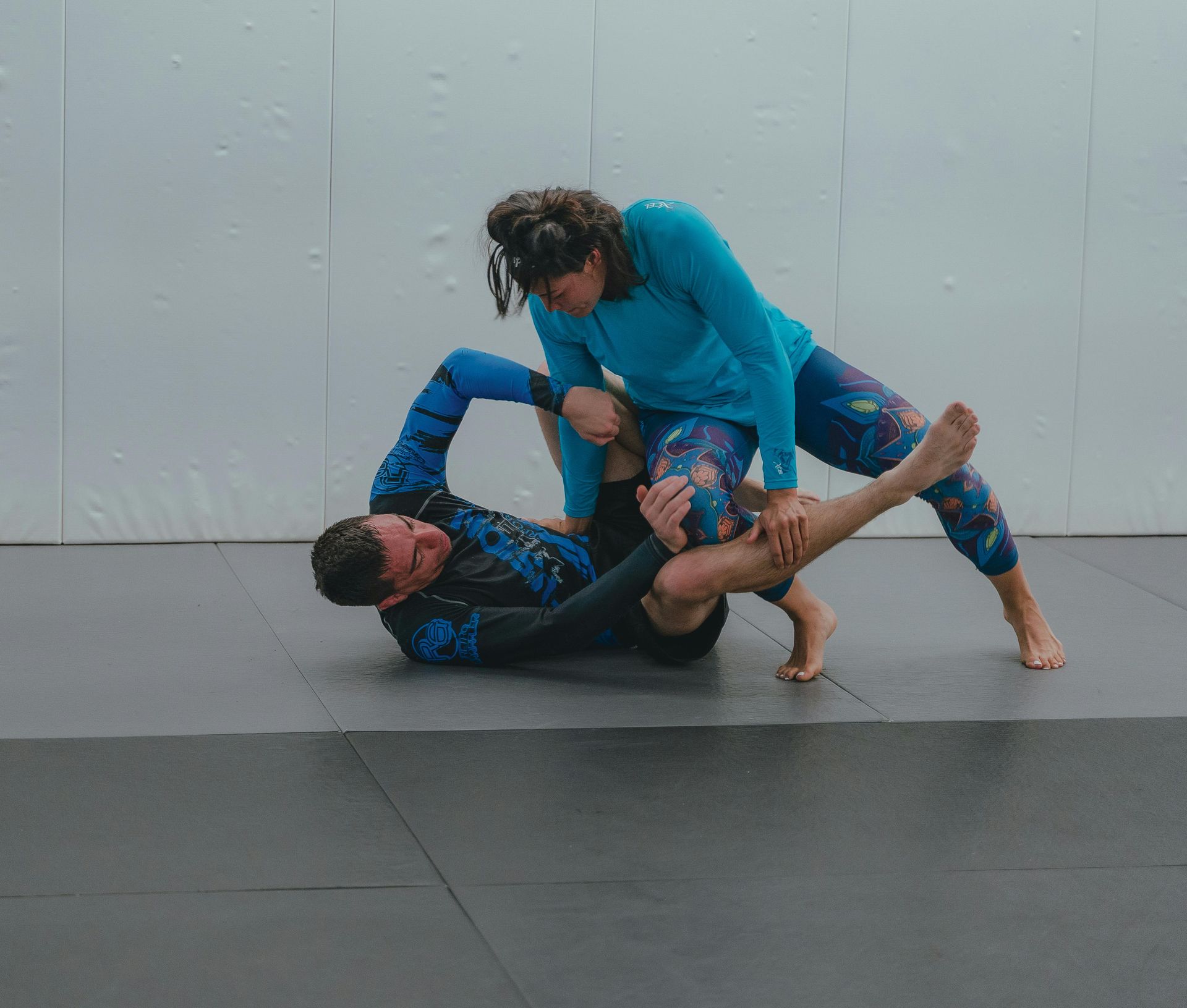A group of men are practicing martial arts on a blue mat