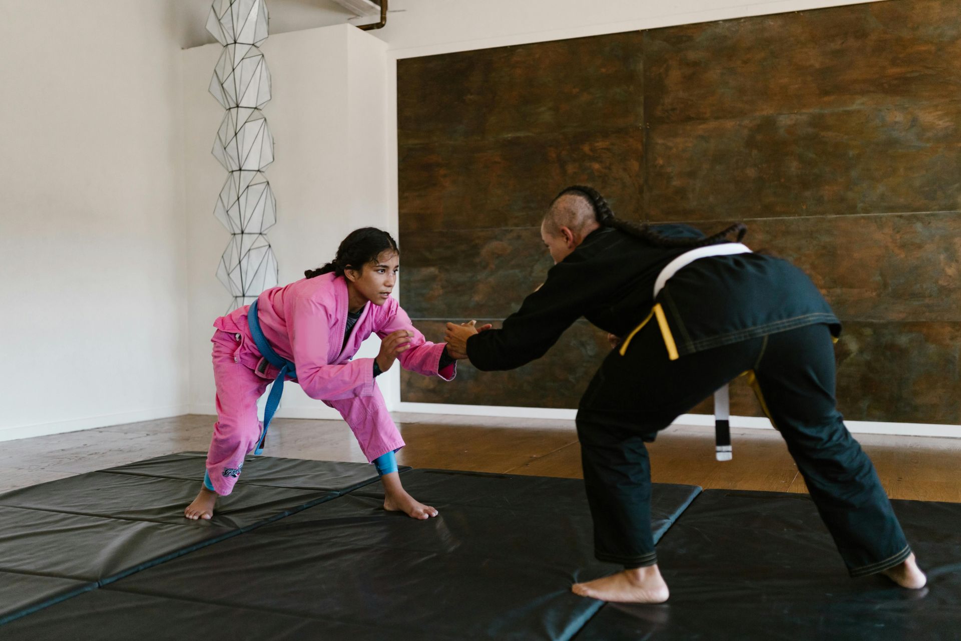 Two girls are practicing martial arts on a mat