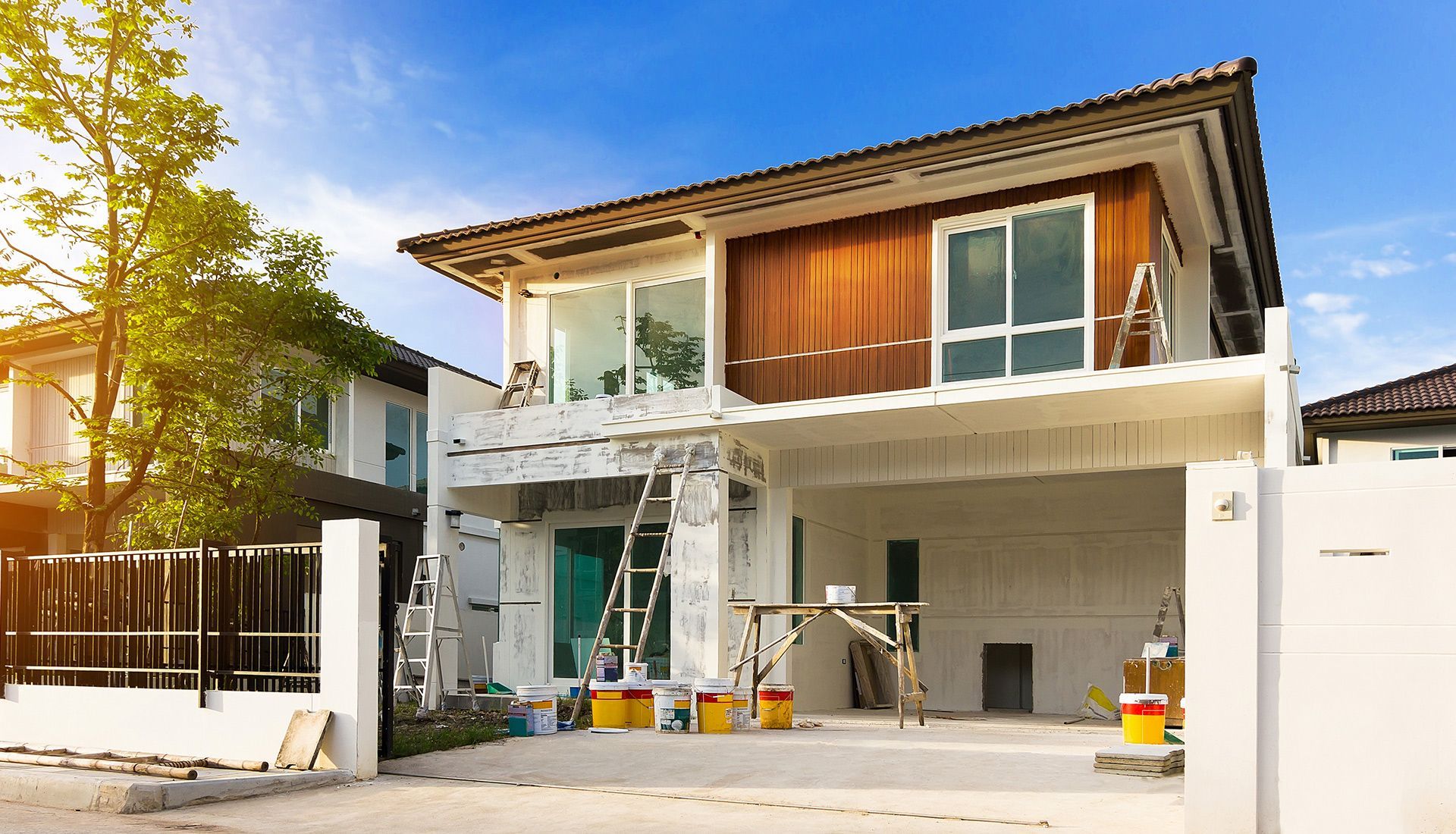 A house is being built in a residential area and is being painted.