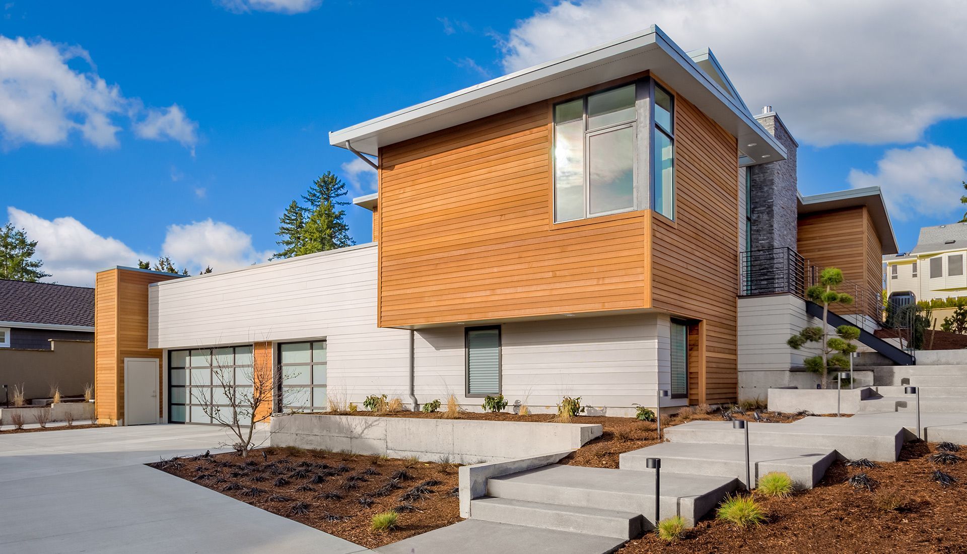 A modern house with a lot of windows and stairs in front of it.