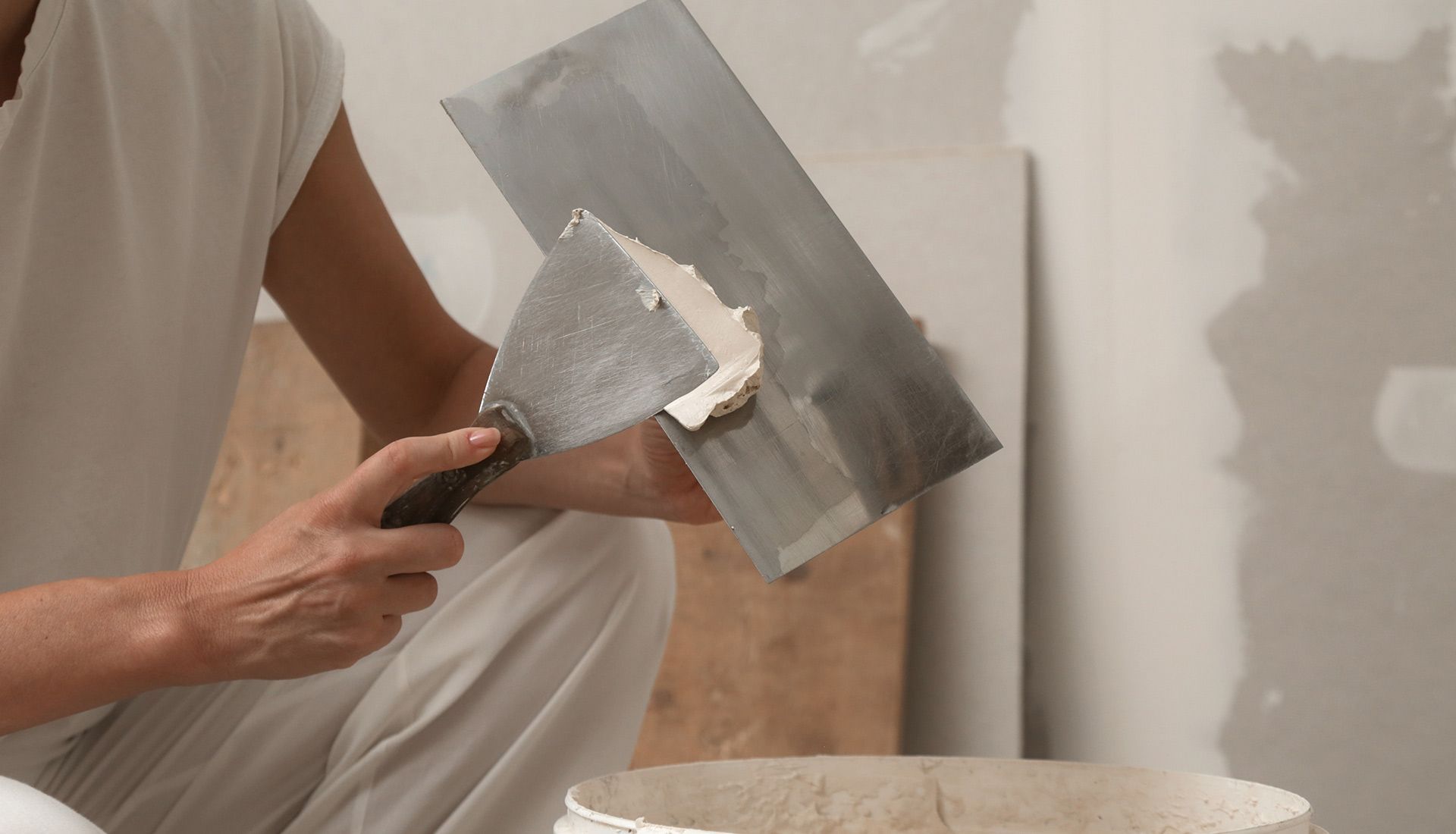 A man is plastering a wall with a spatula.