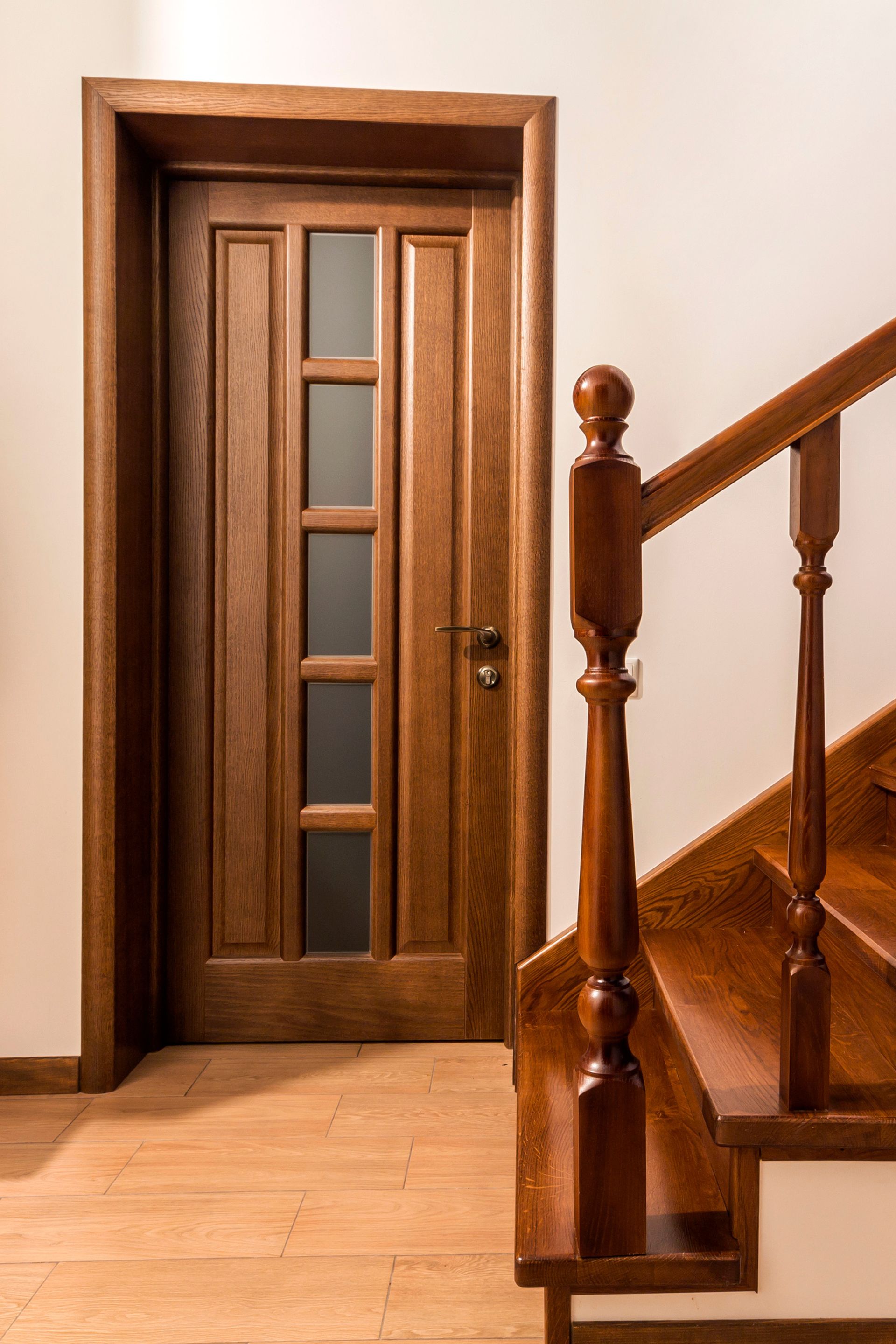 A wooden door and stairs in a hallway.