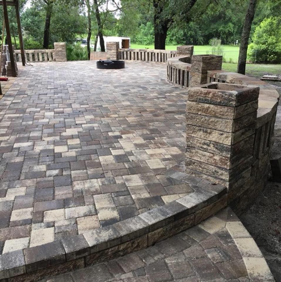 Brick patio with seating and fire pit, surrounded by low stone walls.