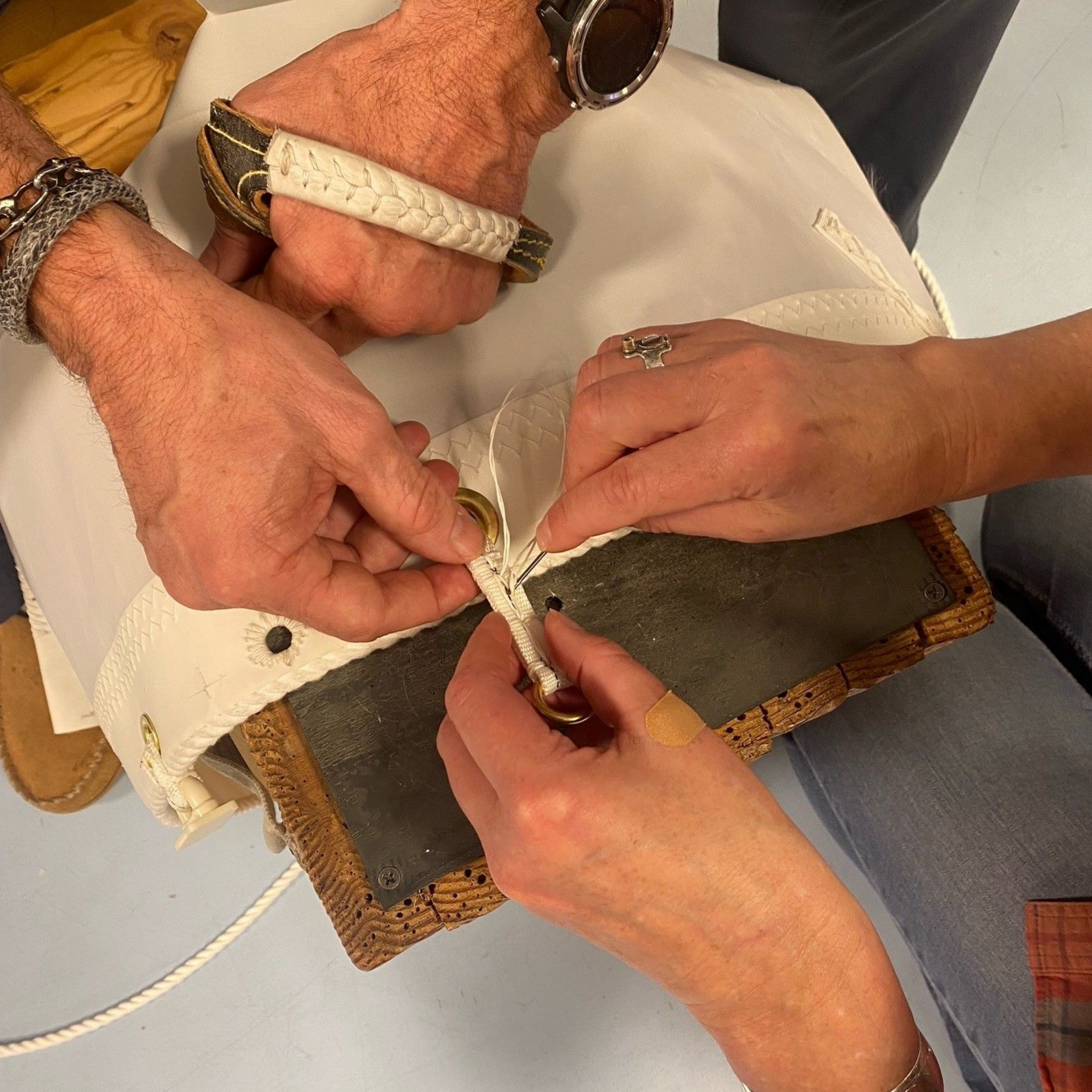 Yellow guitar pick being measured by a silver vernier caliper on a blue background.