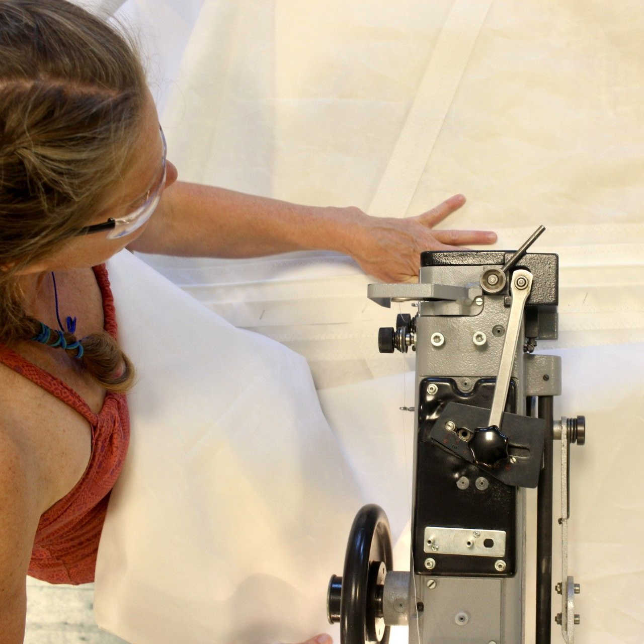 Brown fabric sail with white stitching and leather reinforcements, white straps.