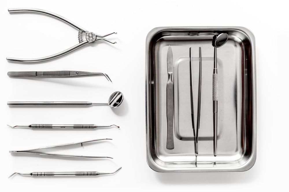 a metal tray filled with dental instruments.