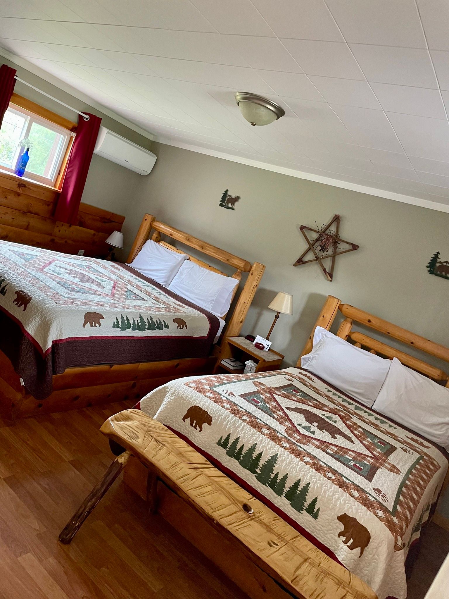 a bedroom with two beds , a bench and a star on the wall .