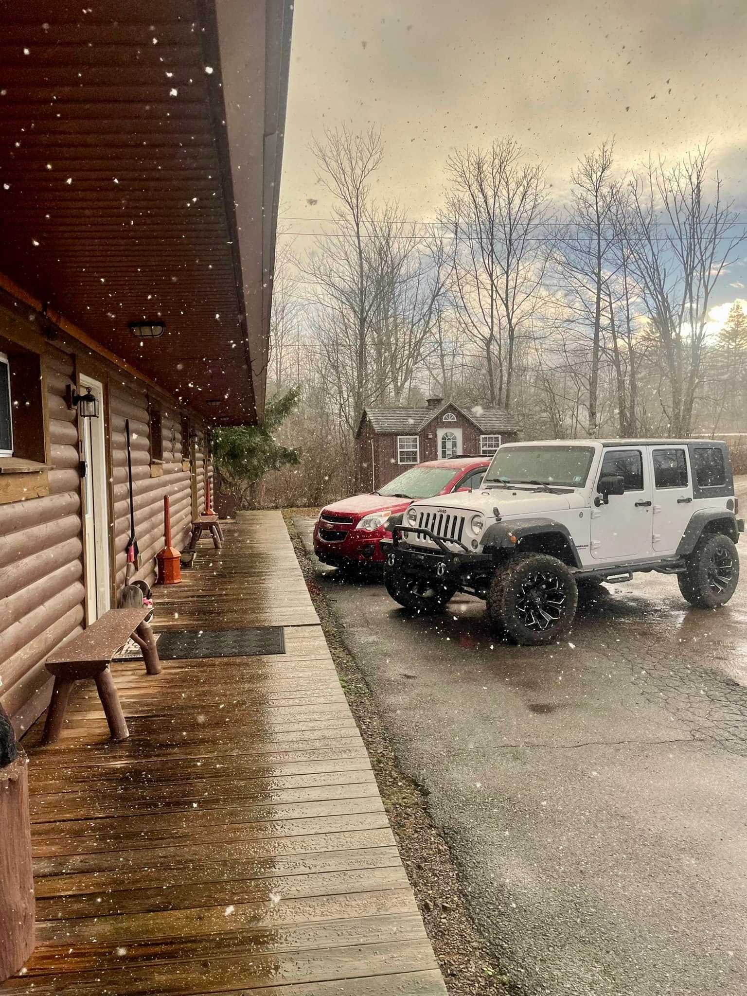 a jeep is parked in front of a log cabin .