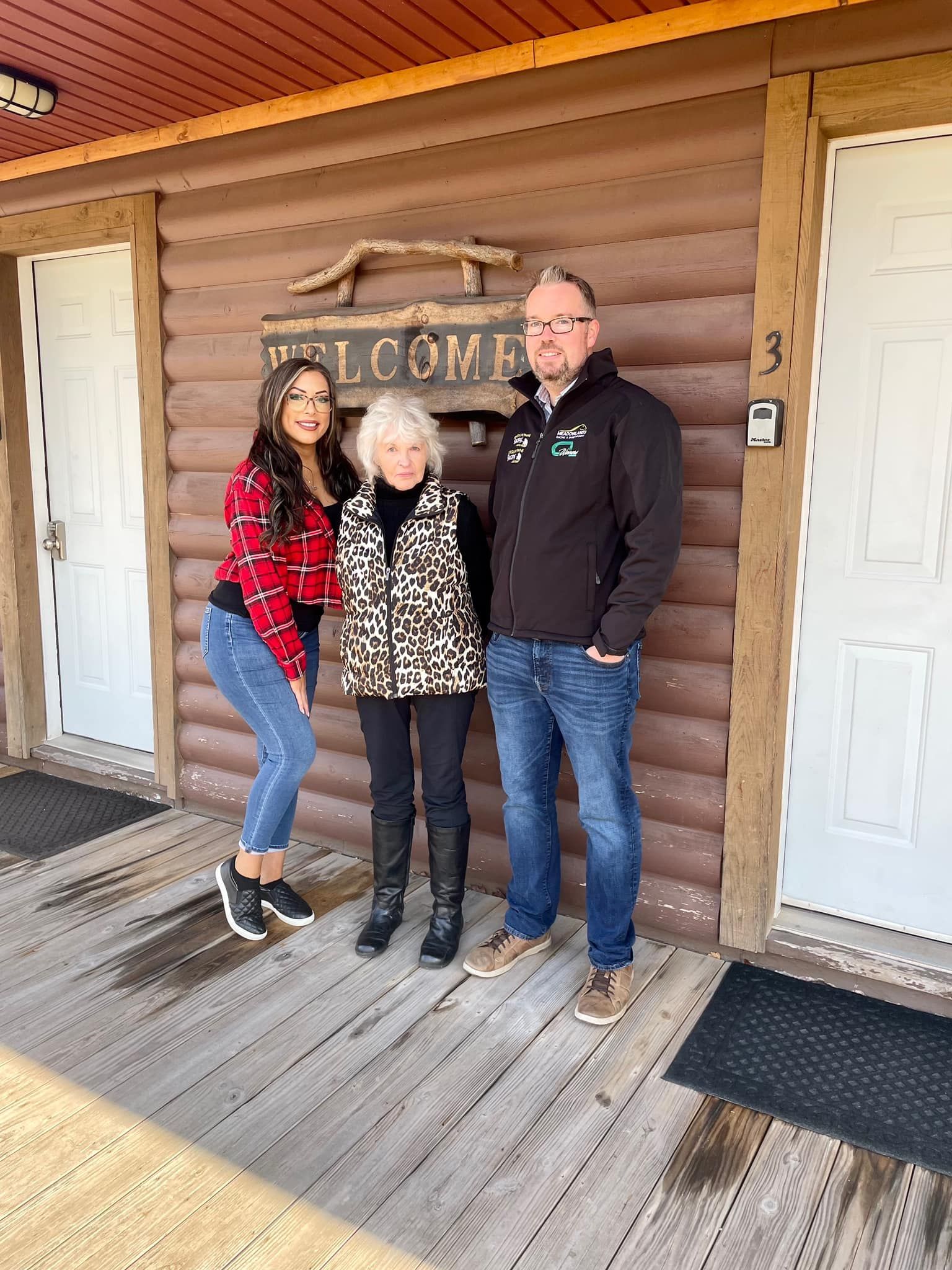 a group of people standing in front of a log cabin .