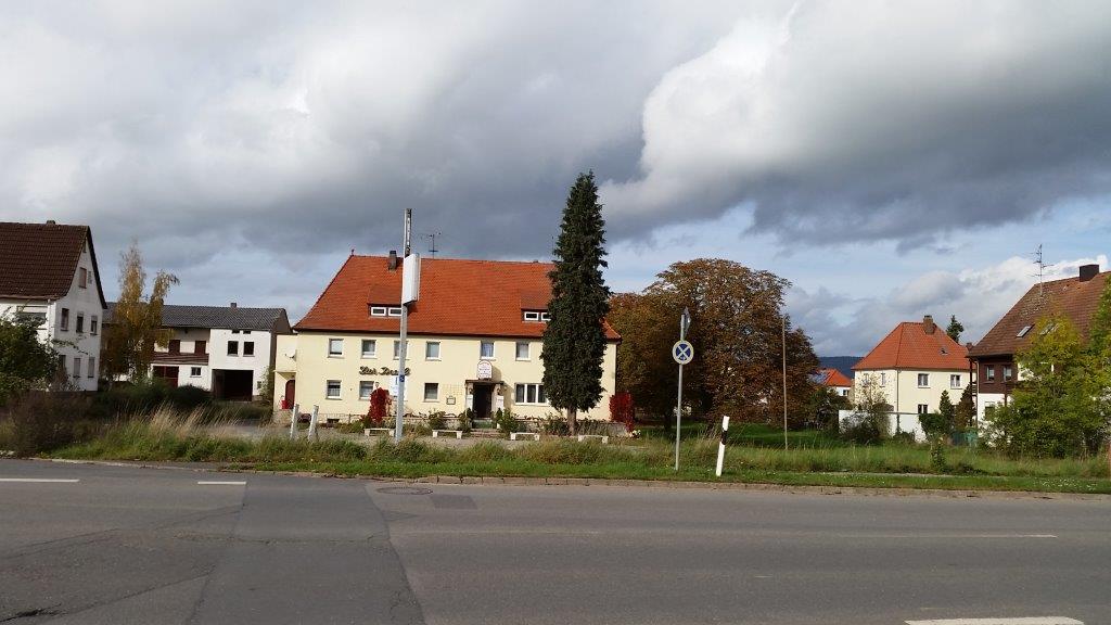 Ein weißes Haus mit einem roten Ziegeldach ist von anderen Häusern umgeben