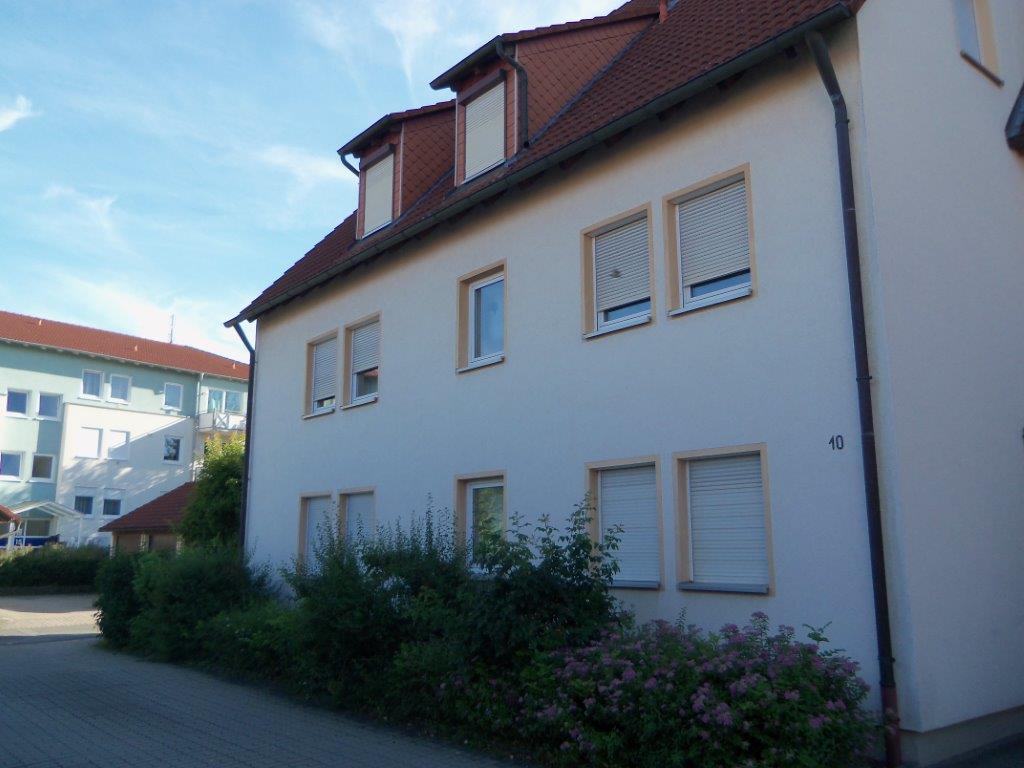 Ein weißes Gebäude mit einem roten Dach und vielen Fenstern