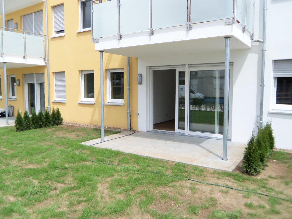 Ein Gebäude mit Balkon und Rasen davor