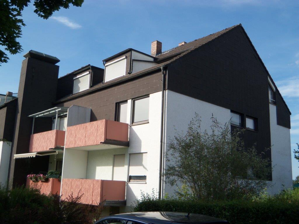 Ein braun-weißes Gebäude mit einem davor geparkten Auto