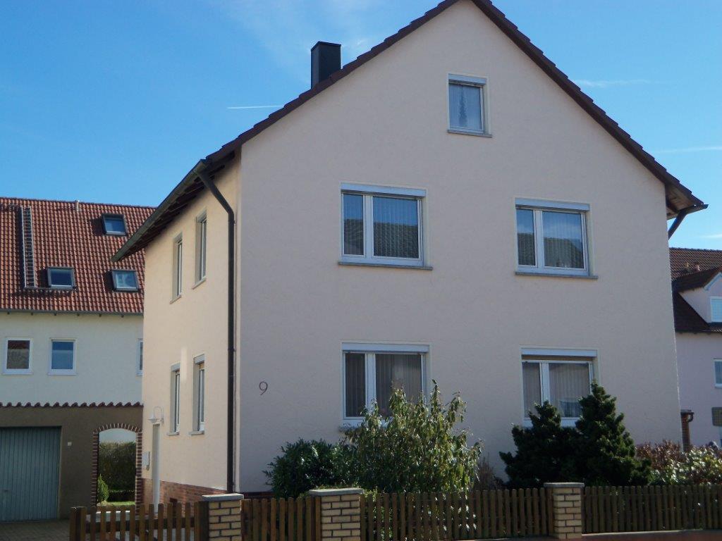 Ein Haus mit einem Holzzaun davor