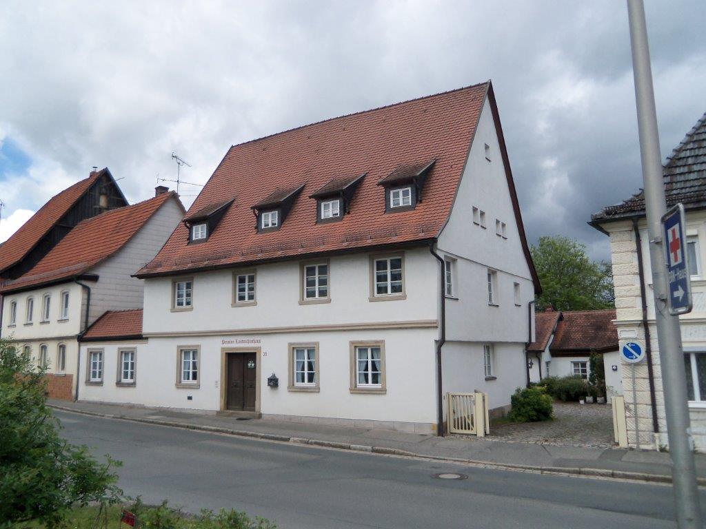 Ein großes weißes Gebäude mit einem roten Ziegeldach
