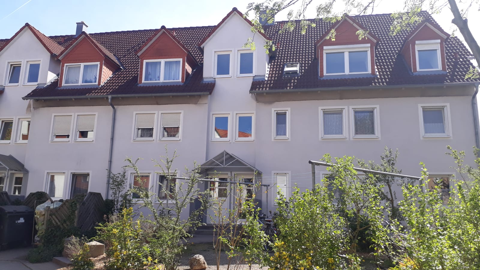 Ein weißes Gebäude mit einem roten Dach und vielen Fenstern