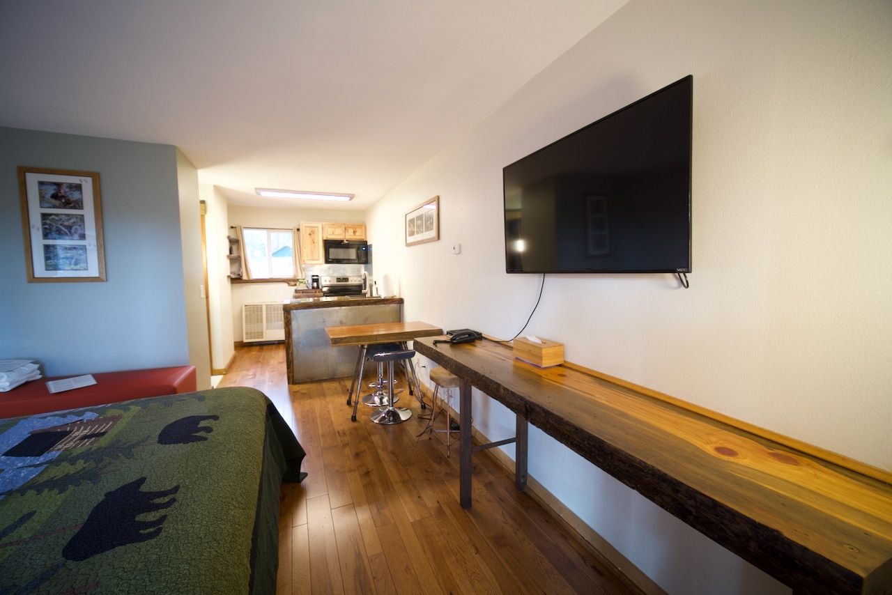 A bedroom with a bed and a flat screen tv on the wall.