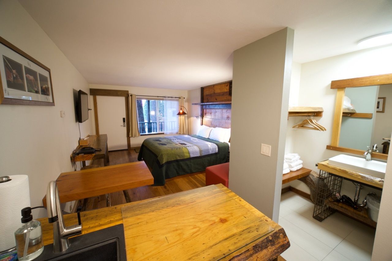 A hotel room with a king size bed and a sink.