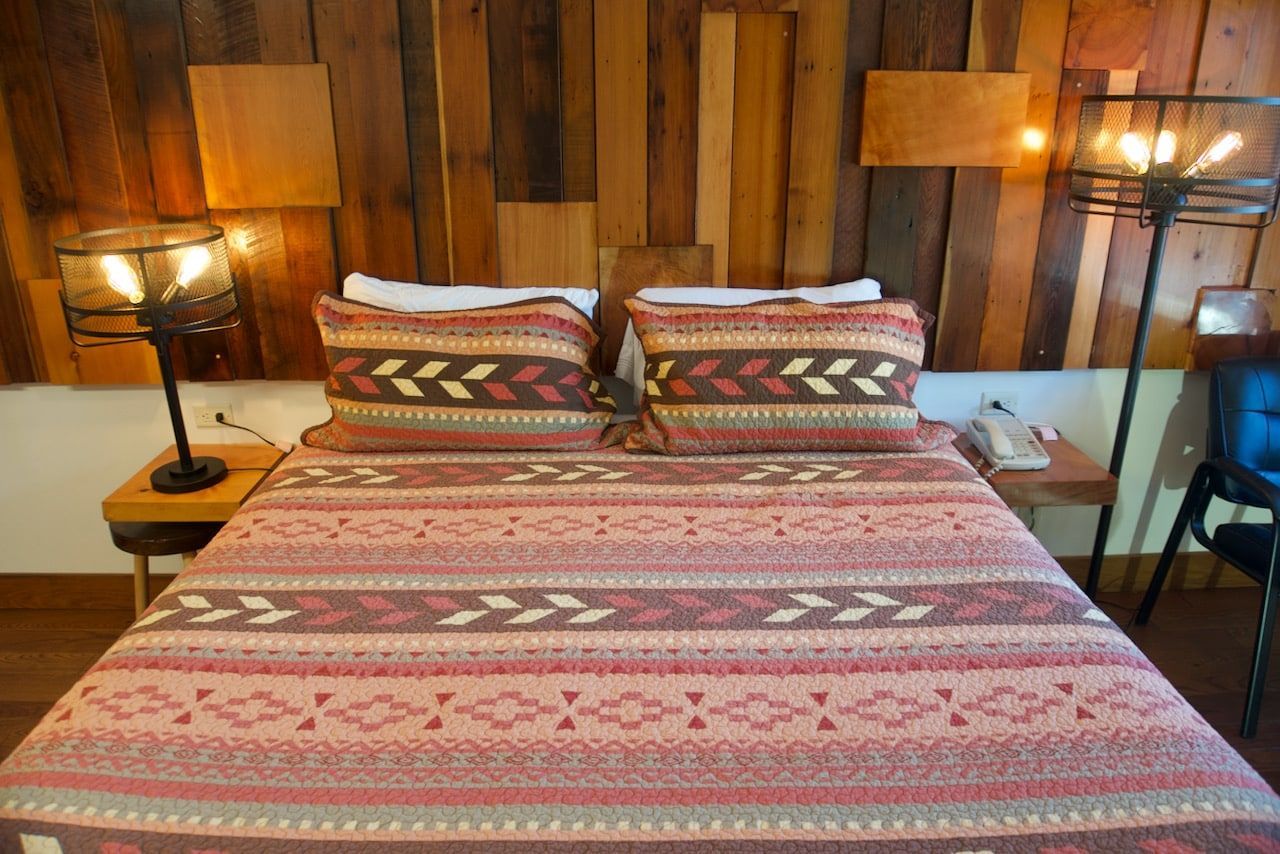 A bed in a room with a wooden headboard