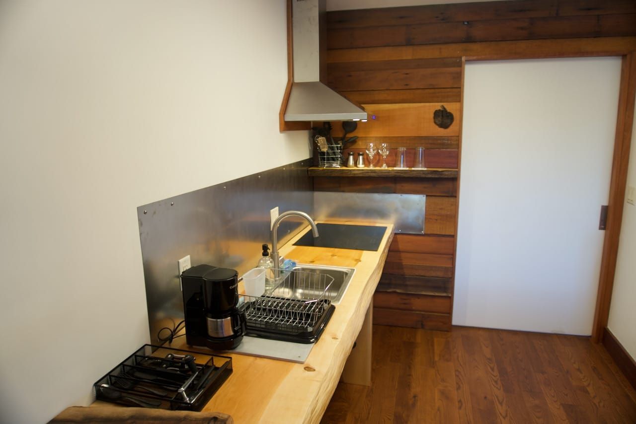 A kitchen with a sink , stove , and coffee maker