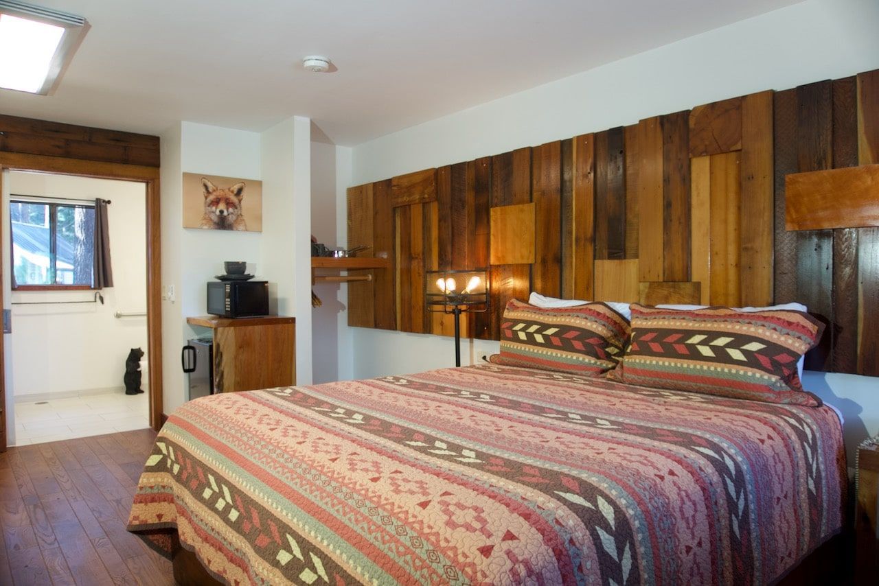 A bedroom with a king size bed and a wooden wall.