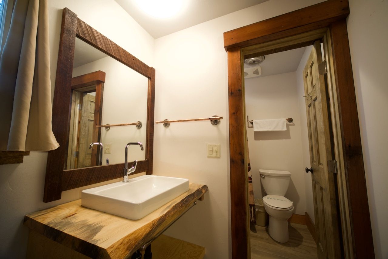 A bathroom with a sink , toilet and mirror.