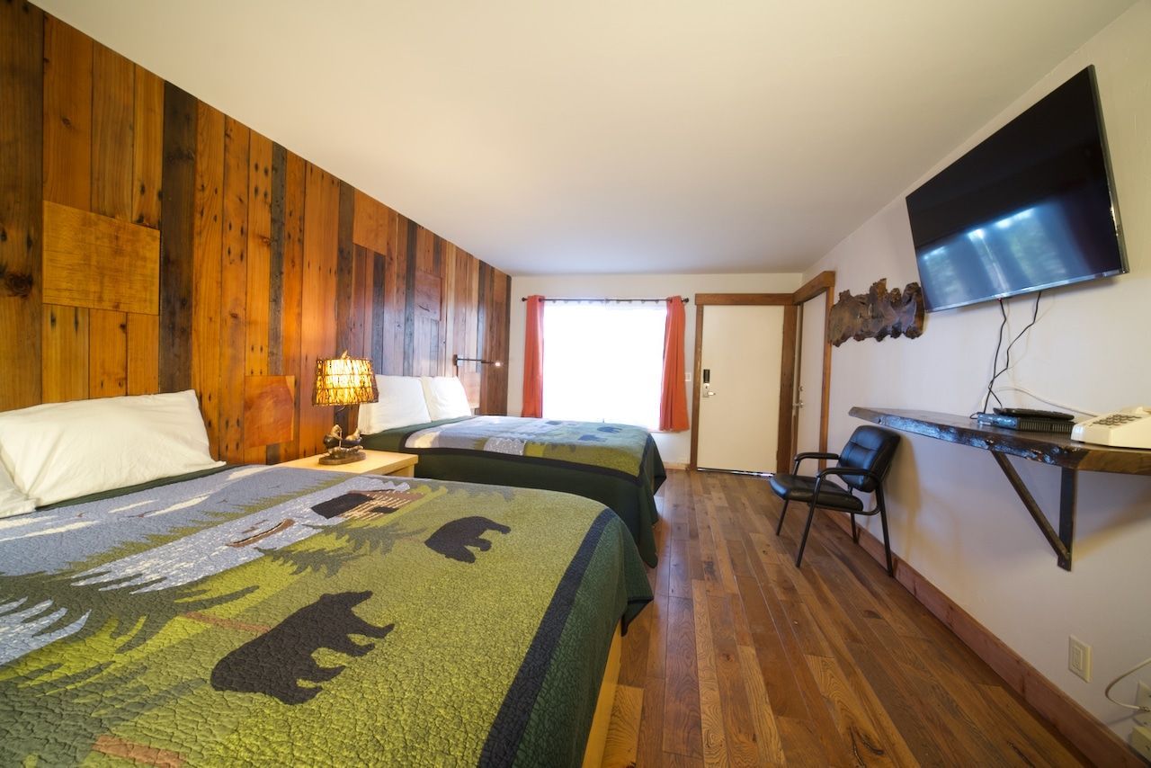 A hotel room with two beds and a flat screen tv