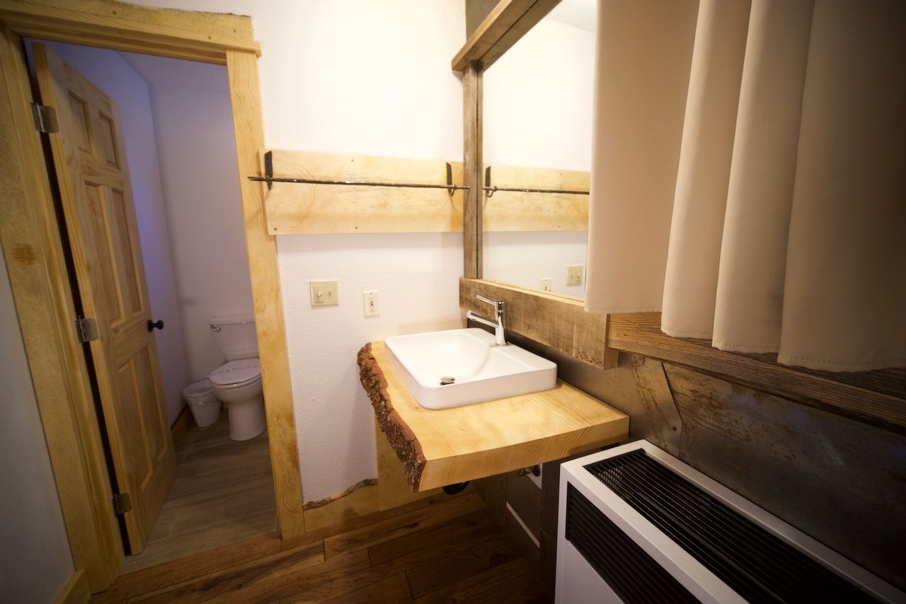 A bathroom with a sink , mirror and toilet.