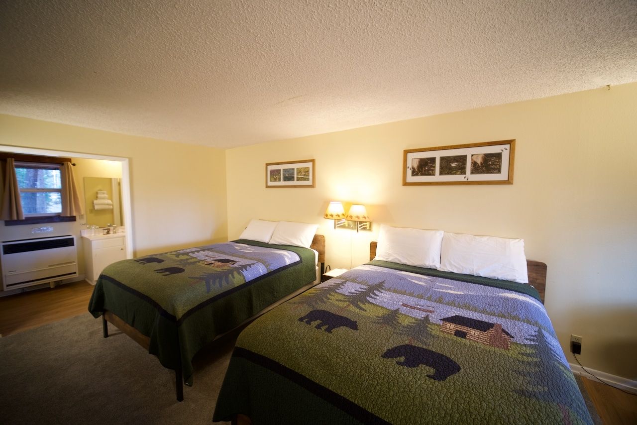 A hotel room with two beds and two pictures on the wall.