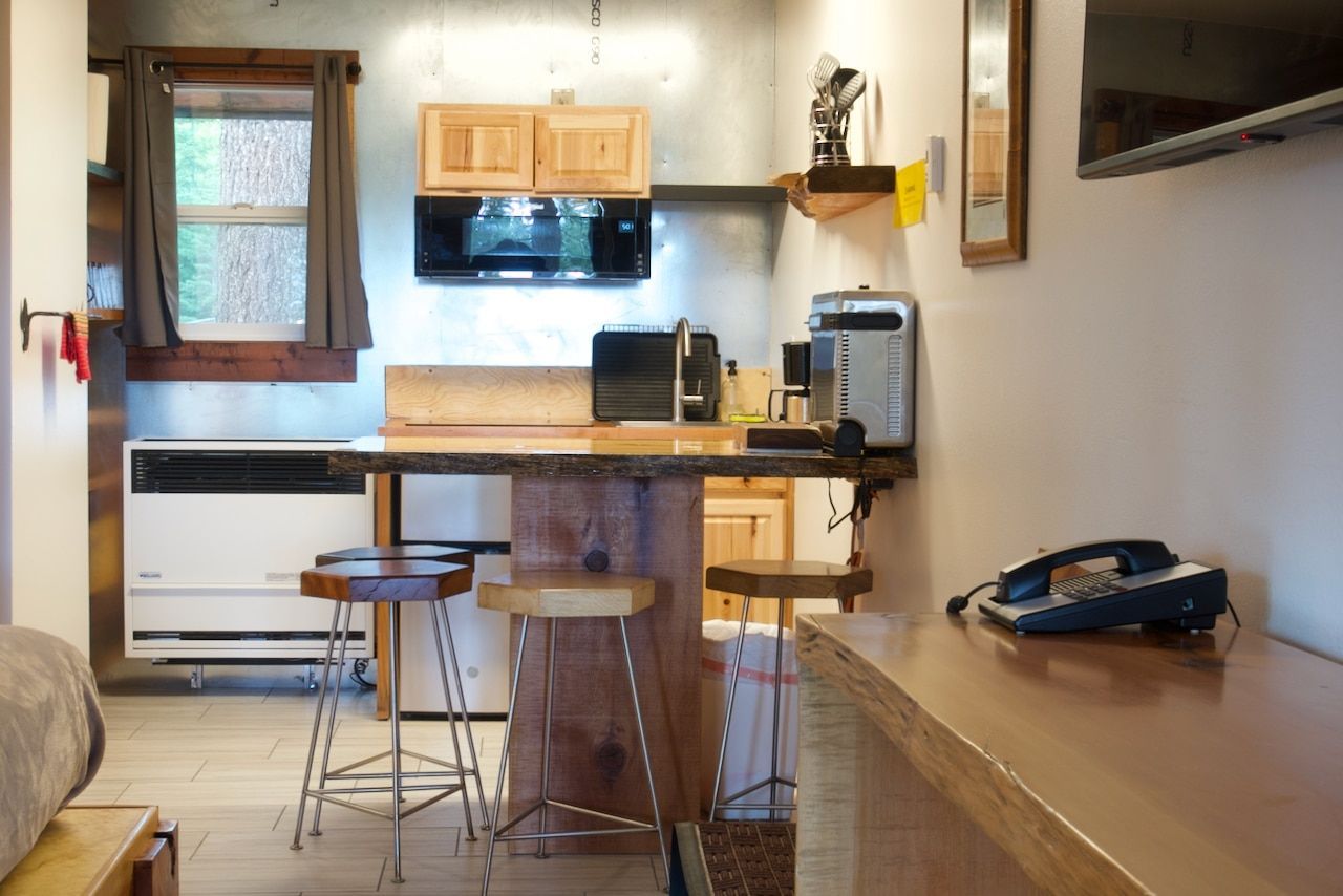 A kitchen with stools and a telephone on the counter