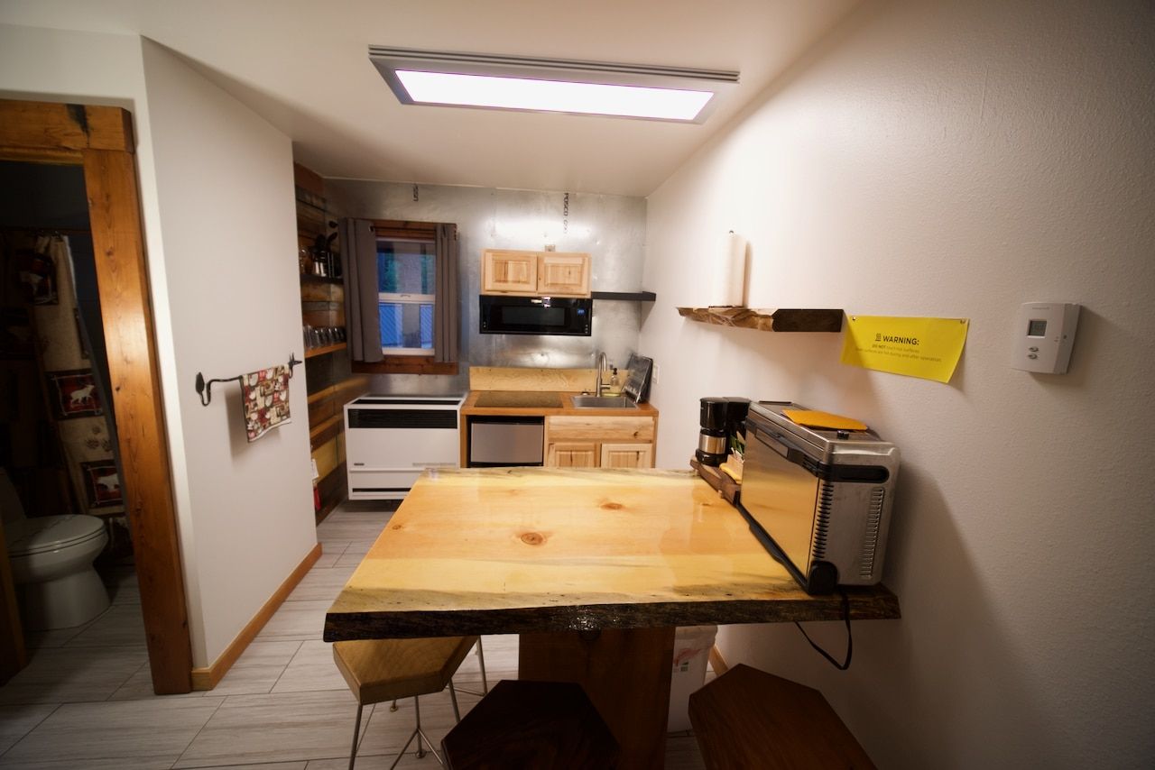 A kitchen with a wooden table and a microwave