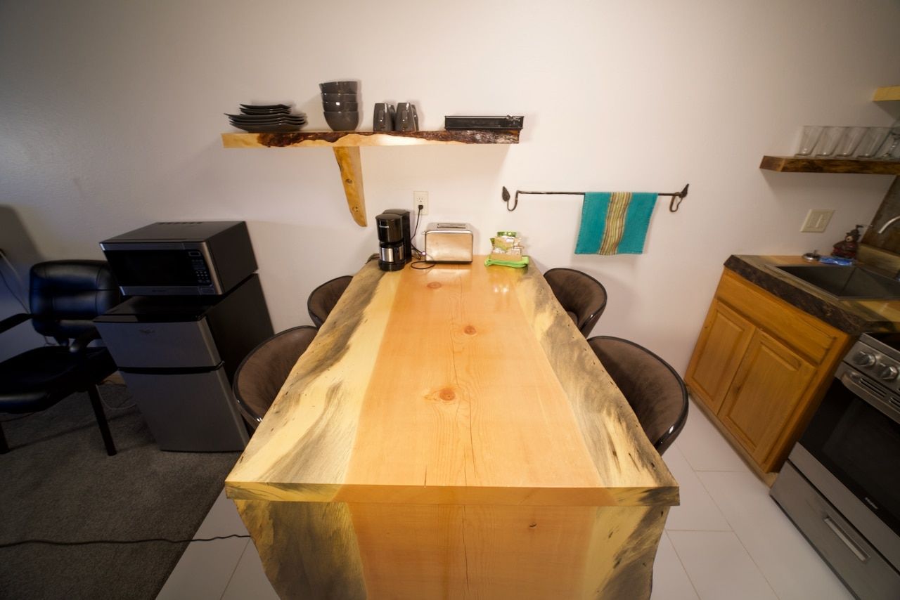 A kitchen with a large wooden table and chairs