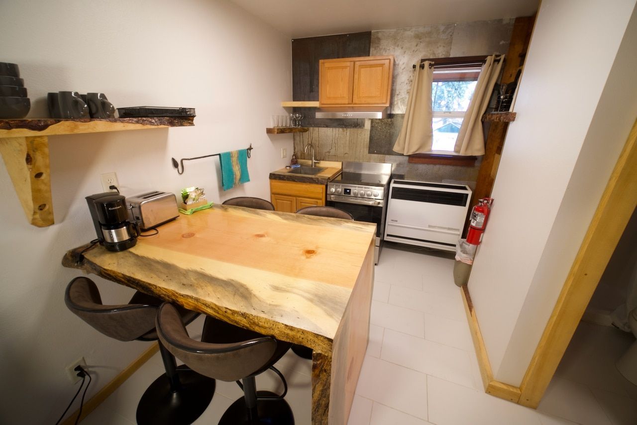 A kitchen with a wooden table and chairs