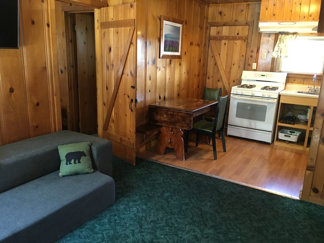 A living room with a couch and a pillow with a bear on it