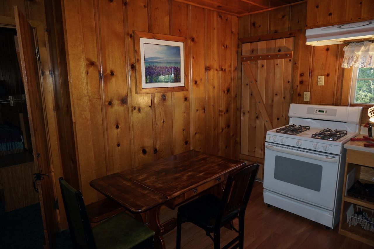 A kitchen with a table and chairs and a stove.