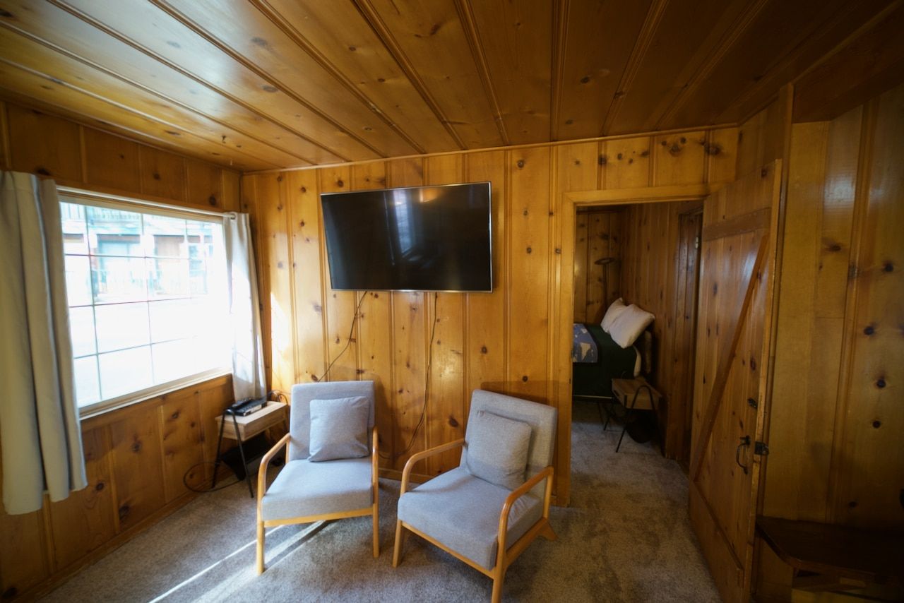 A living room with two chairs and a flat screen tv.