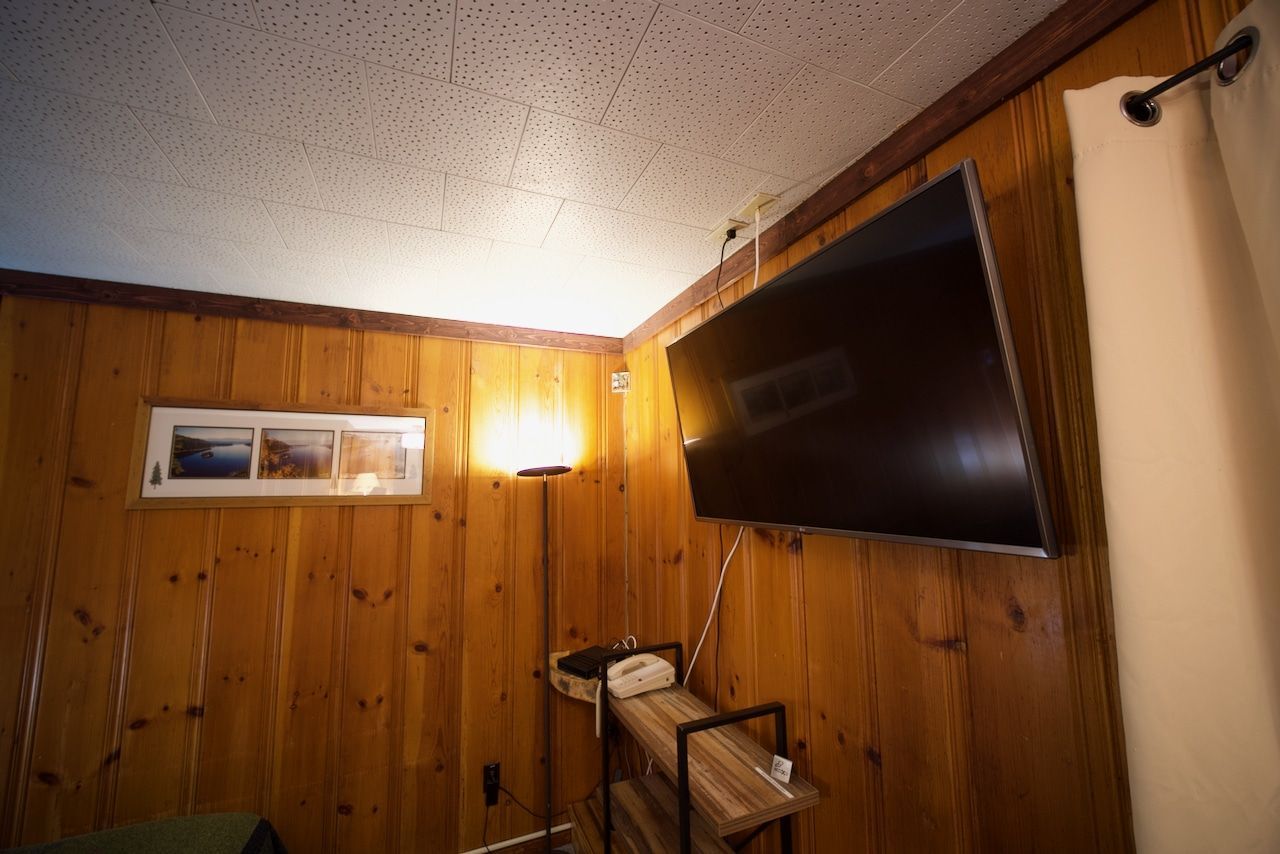 A room with wood paneling and a flat screen tv on the wall.