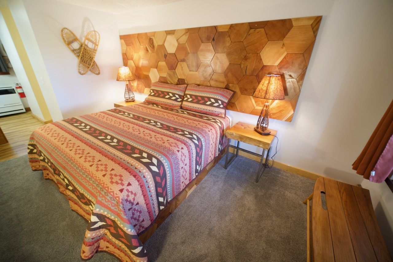 A bedroom with a king size bed and a wooden headboard.