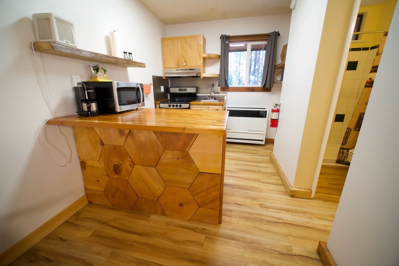 A kitchen with a wooden counter top , stove and microwave.