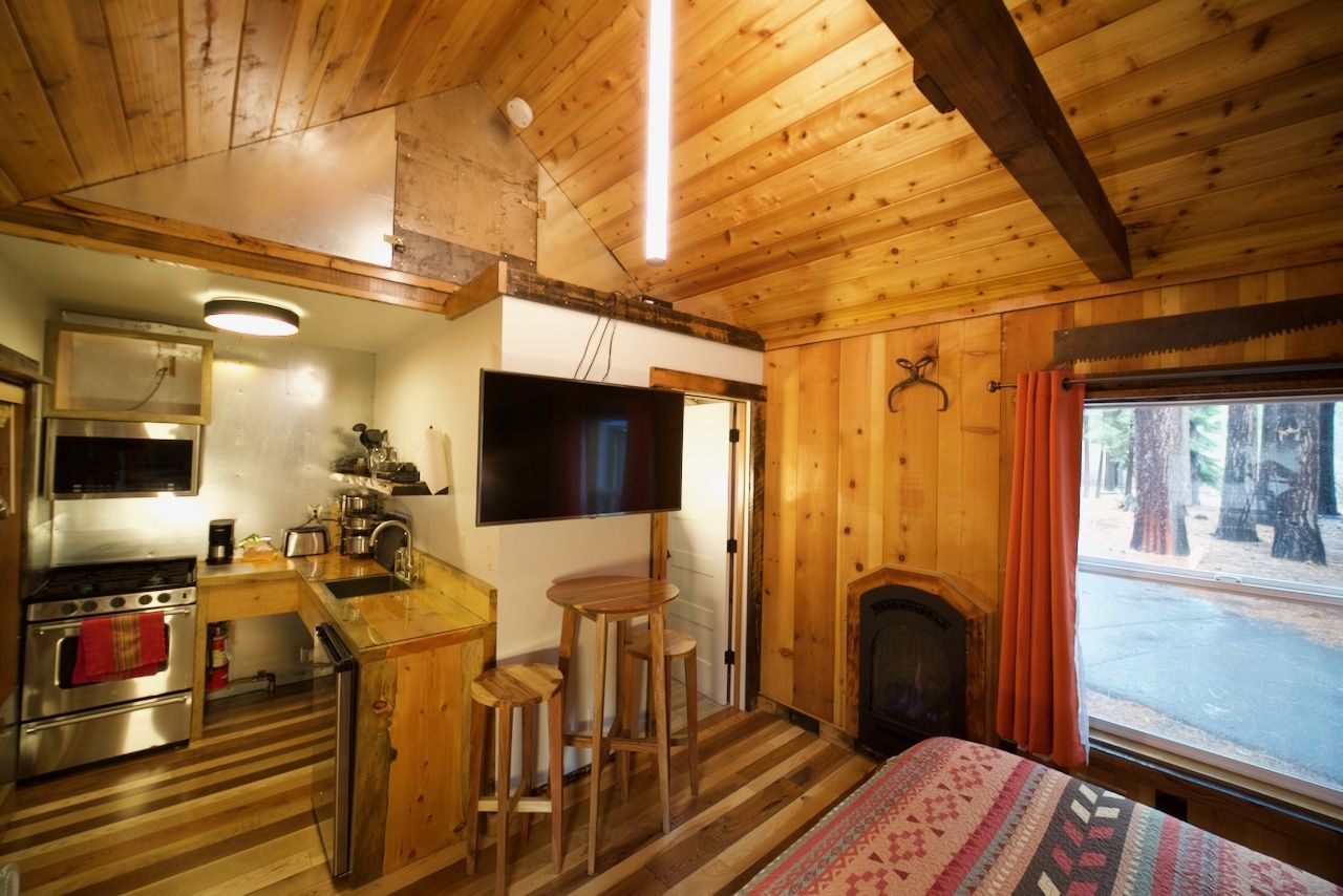 A wooden cabin with a bed and a flat screen tv.