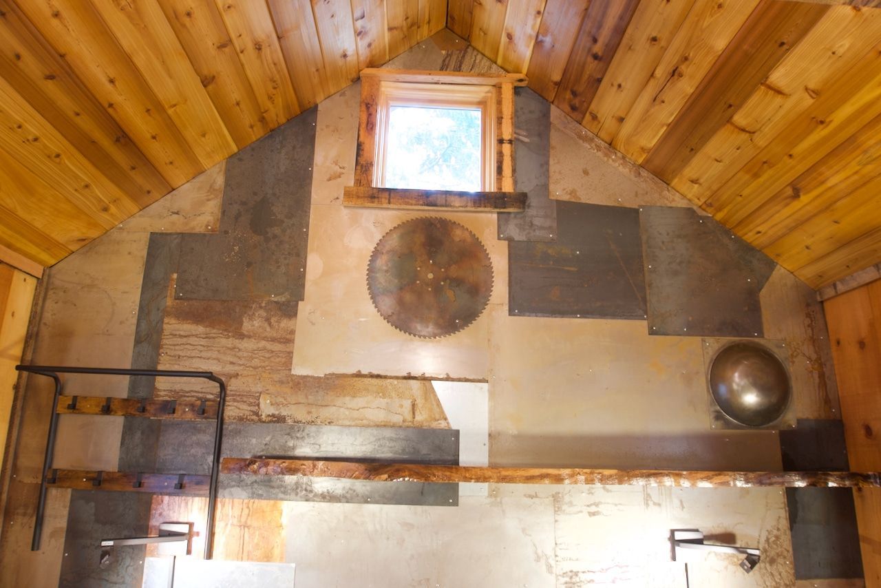 A bathroom with wooden walls and a window.